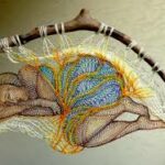 Exposition de dentelle dans l'ancienne église Saint-Gilles à Ambialet - oeuvre en dentelle brodée d'Agnès Herczeg représentant une femme qui dort