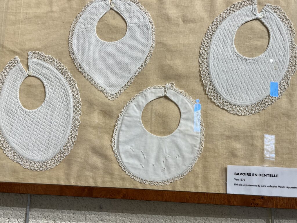 Exposition de dentelle dans l'ancienne église Saint-Gilles à Ambialet - bavoirs en dentelle du XIXème siècle prêtés par le musée départemental du textile du Tarn